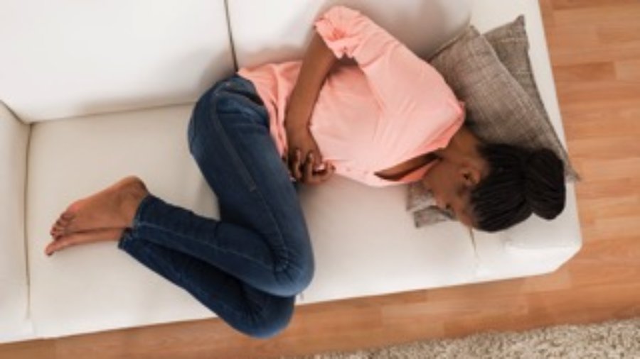 Woman Lying On Couch With Stomach Pain - charlotte food sensitivity testing