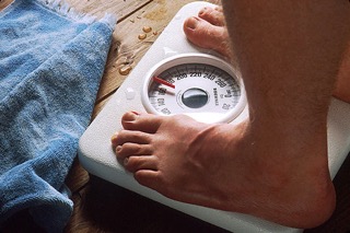 Man Weighing Himself - charlotte weight loss programs