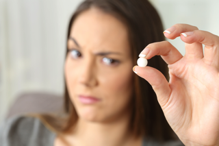 Unhappy Woman Holding Pill - charlotte inflammation treatment