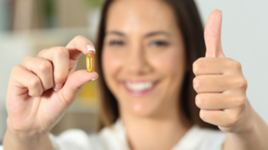 Woman Holding Pill - hormone imbalance treatment in charlotte